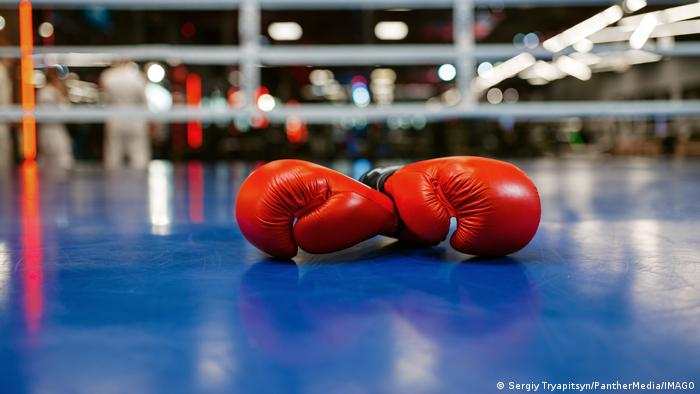 Symbolic image of boxing gloves lying on the floor of the boxing ring