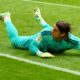Bayern Munich goalkeeper Yann Sommer lies on his stomach after a failed save and looks after the ball into the goal
