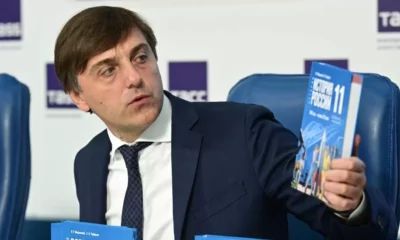 Russian Education Minister Sergei Kravtsov holds a new schoolbook for high school students on world history and Russian history on August 7, 2023.