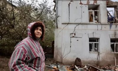 A woman stands near a destroyed building in the city of Kupiansk, north-eastern Ukraine. Photo: April 2023