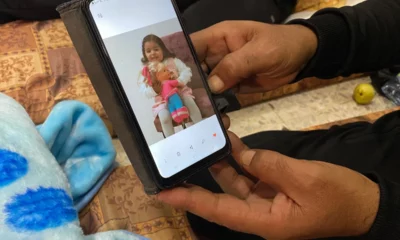 Ismail Abd Almagid looks at a picture of his daughter on his phone