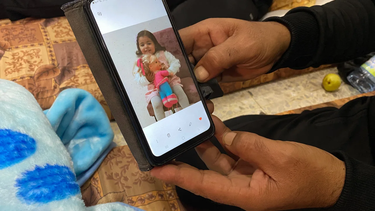 Ismail Abd Almagid looks at a picture of his daughter on his phone