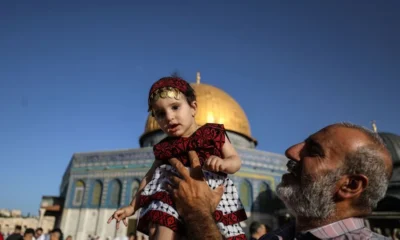 Getty Images Man carrying little girl dressed in traditional Palestinian attire