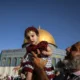 Getty Images Man carrying little girl dressed in traditional Palestinian attire