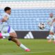 Che Adams prepares to volley the ball with his right foot, wearing Scotland's light blue away top, in the win at in Gibraltar