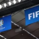 Euro 2024 and Fifa flags hanging from a stadium roof