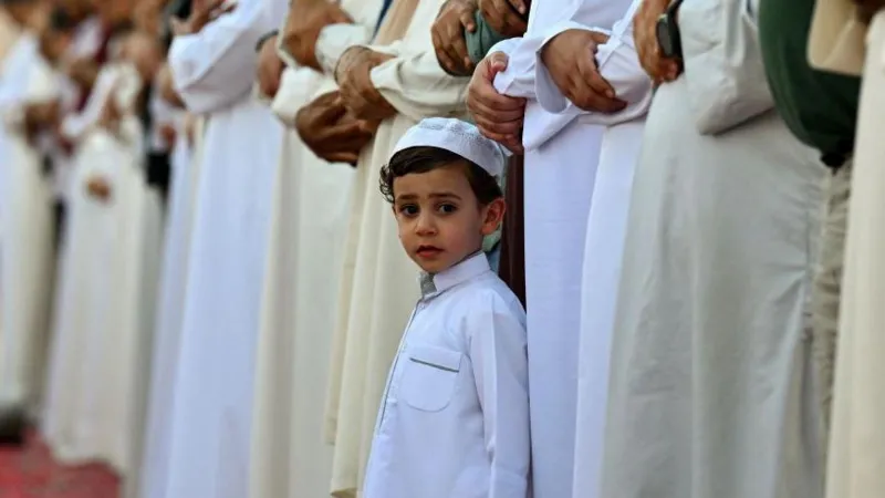 Getty Images A little boy looks surrounded by worshippers looking out at the camera