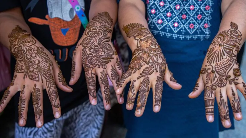 Getty Images Girls showing off their henna