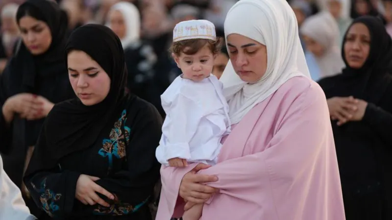 Getty Images A woman holding a baby as she prays