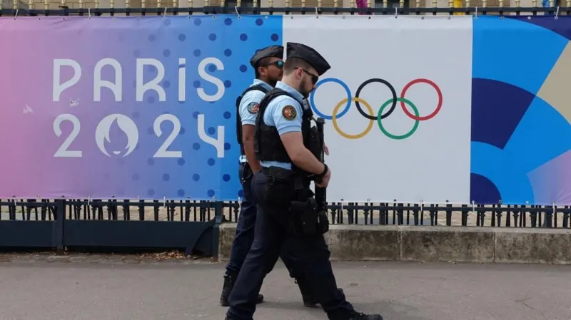 REUTERS/Fabrizio Bensch Police patrol a street near a poster advertising the Paris 2024 Olympic Games in Paris